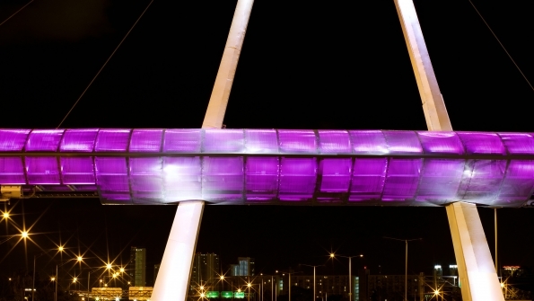 Purple LED lighting illuminates a toll gantry in Florida