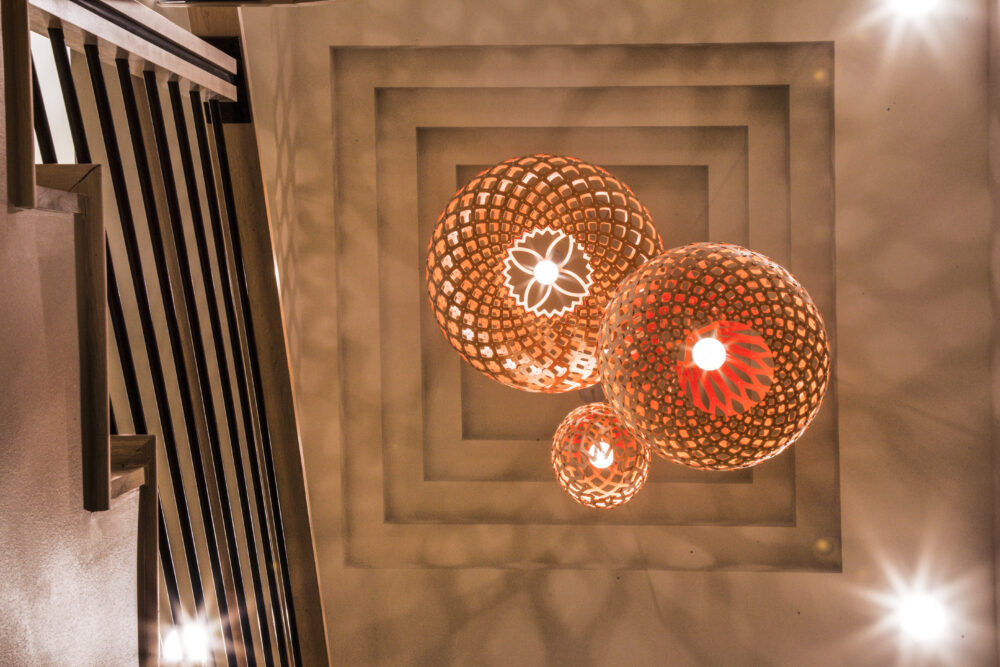 A photo taken directly below an installation of intricate pendant lamps at Sailfish Point Fitness Center